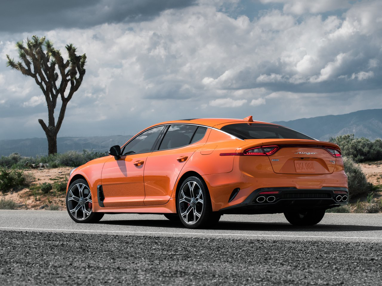An orange Kia Stinger GT S stopped on a road