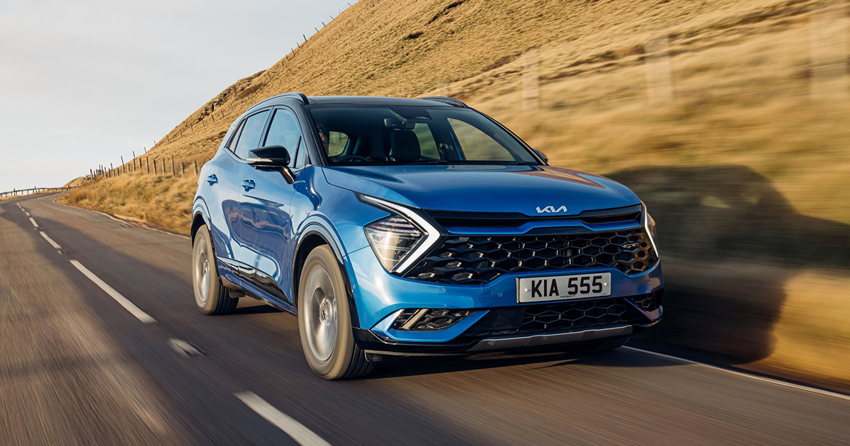 Front angle of a blue Kia Sportage driving