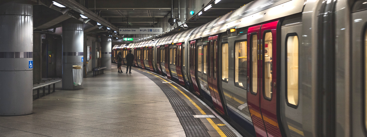 An underground tube station with a train at the platform