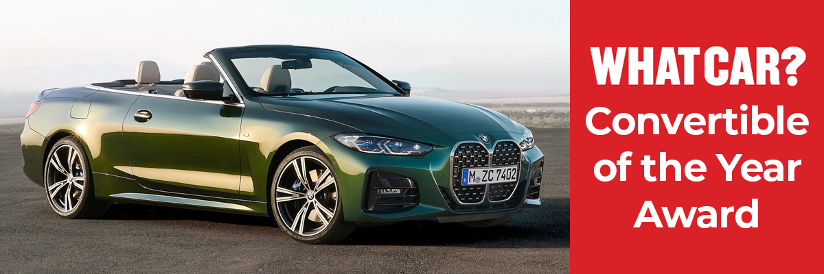 A green BMW 4 Series Convertible with the roof down