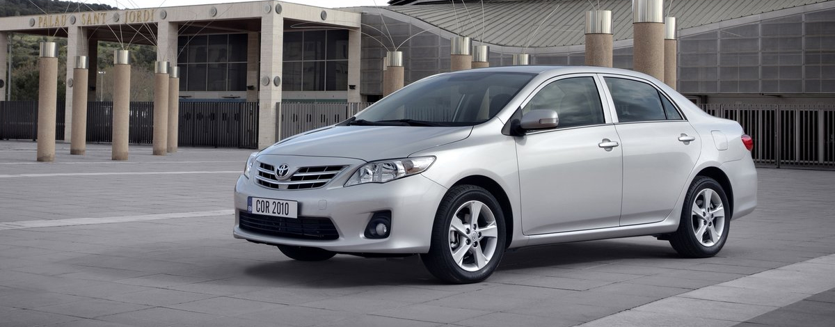The popular Toyota Corolla parked on the pavement outside a large building
