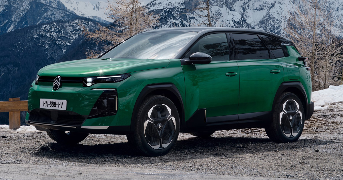 Green Citroën e-C5 parked in front of a mountain