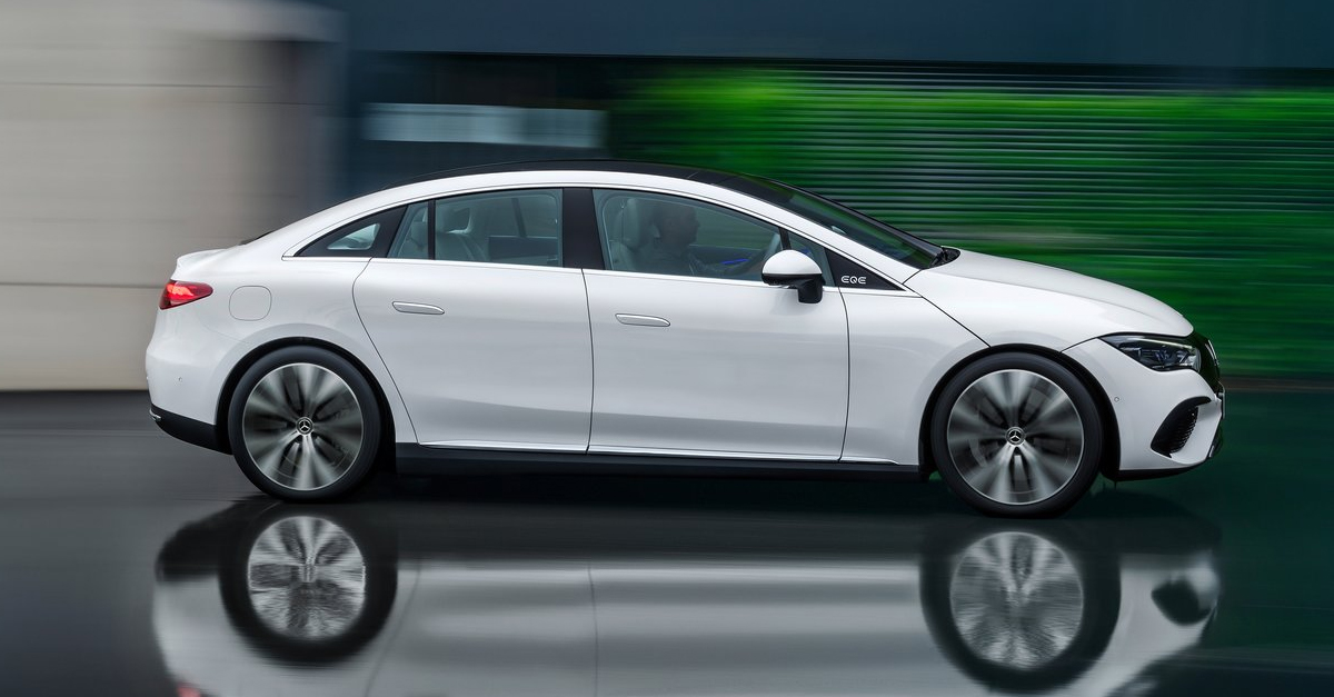 Side view of a Mercedes-Benz EQE driving on a shiny surface