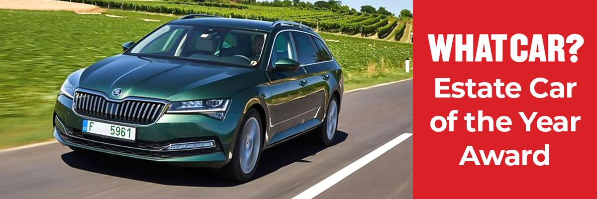 A green Skoda Superb Estate driving down a country road