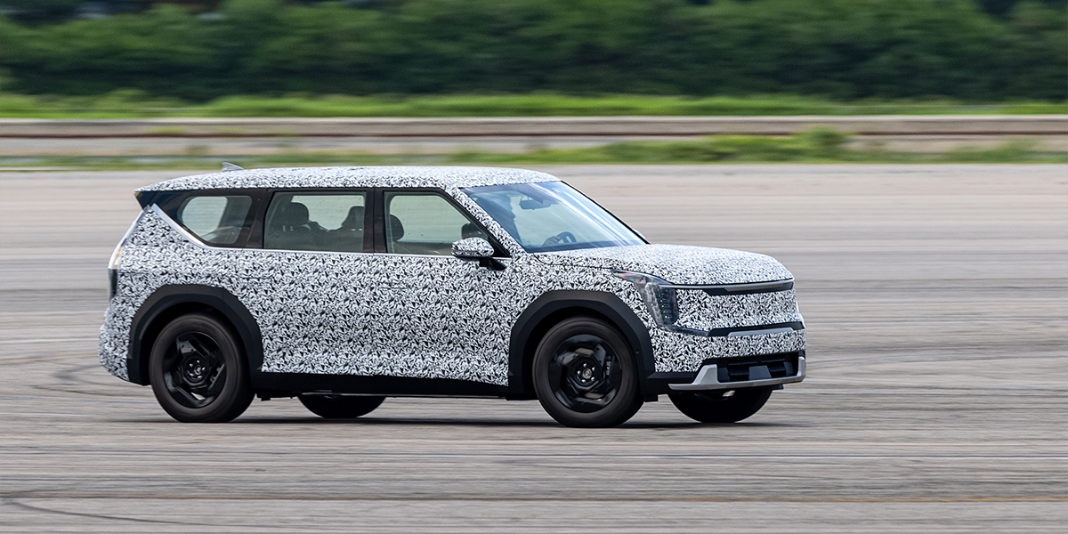Side view of a Kia EV9 in a camoflage wrap