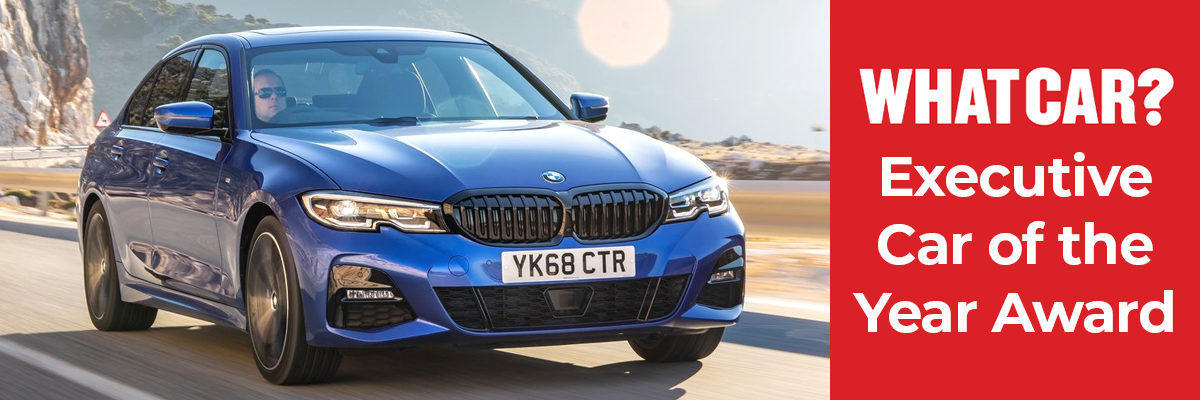 a blue BMW 3 Series driving down a cliffside road