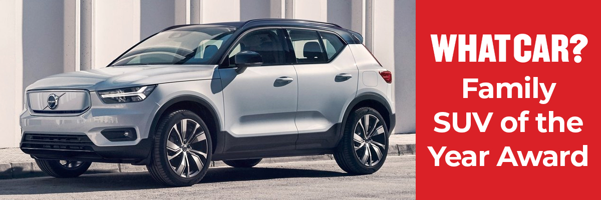 A white Volvo XC40 parked next to the pavement