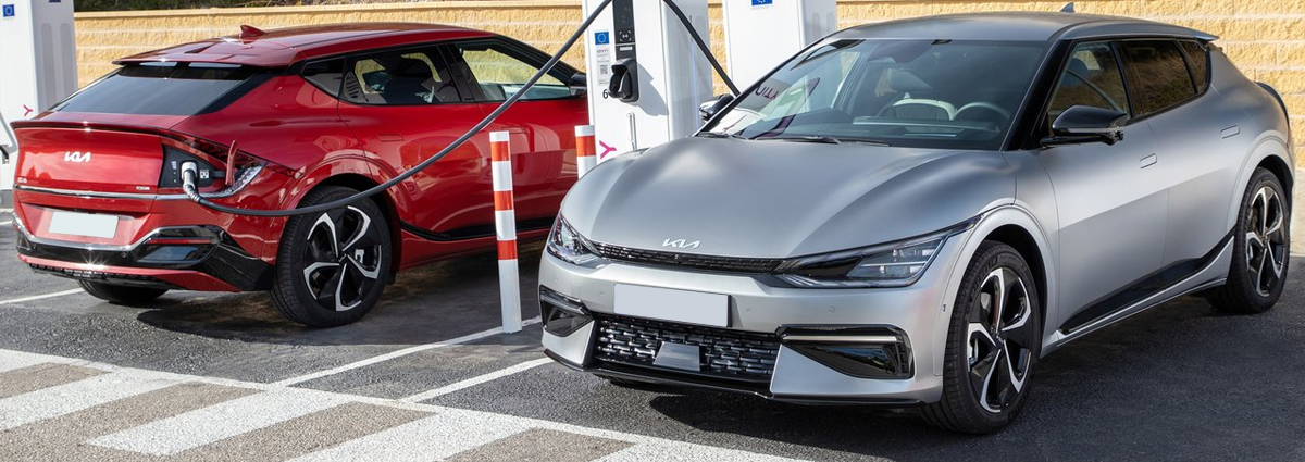 A red and a silver Kia EV6 charging
