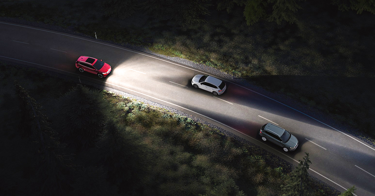A car driving down a road with bright headlights on