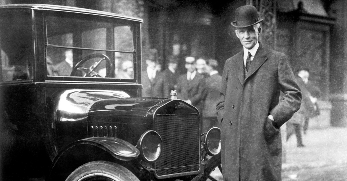 Black and white image of Henry Ford next to a Model T car