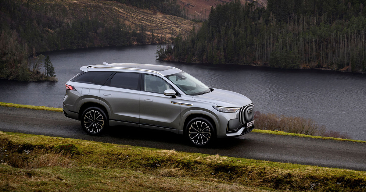 Side angle of the Jaecoo 8 driving past a lake