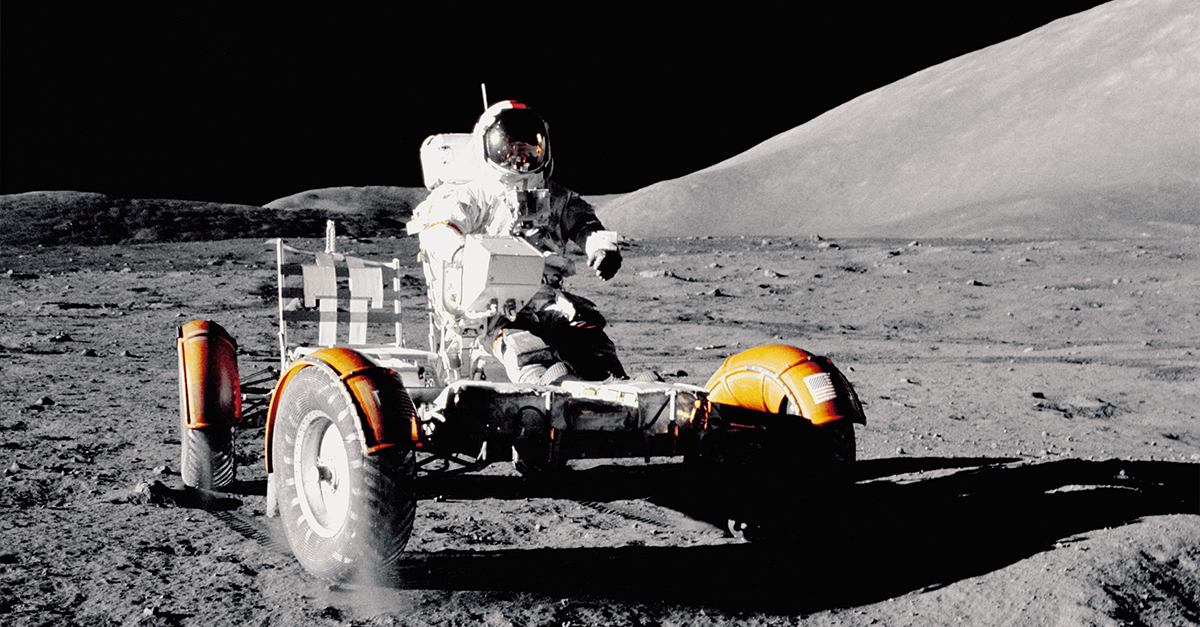 An astronaut driving a moon buggy on the moon's surface