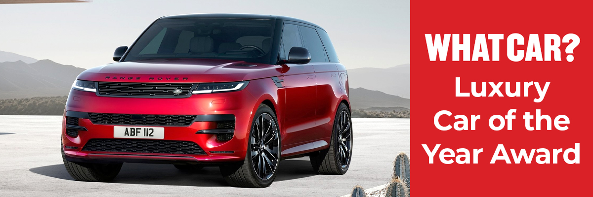 A red Land Rover Range Rover Sport with hills in the background