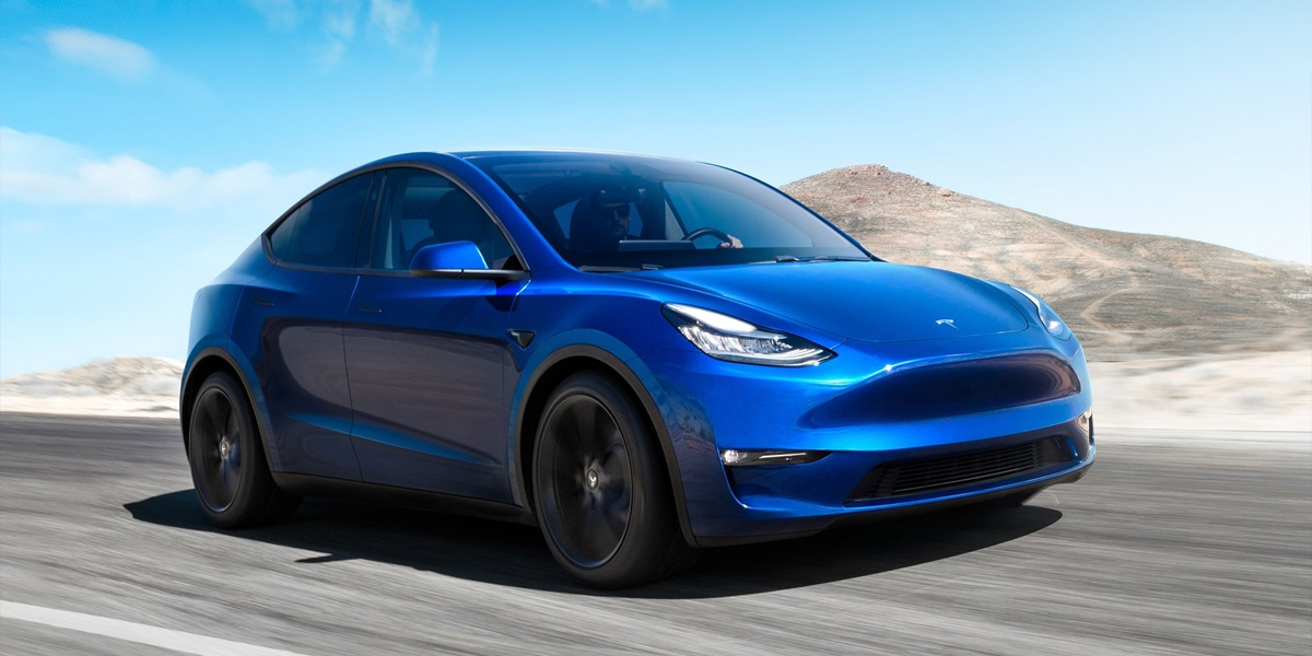 a blue Tesla Model Y driving down a road