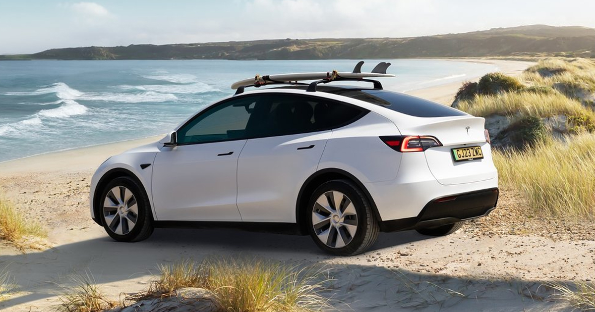 Rear angle of the Tesla Model Y SUV on a beach