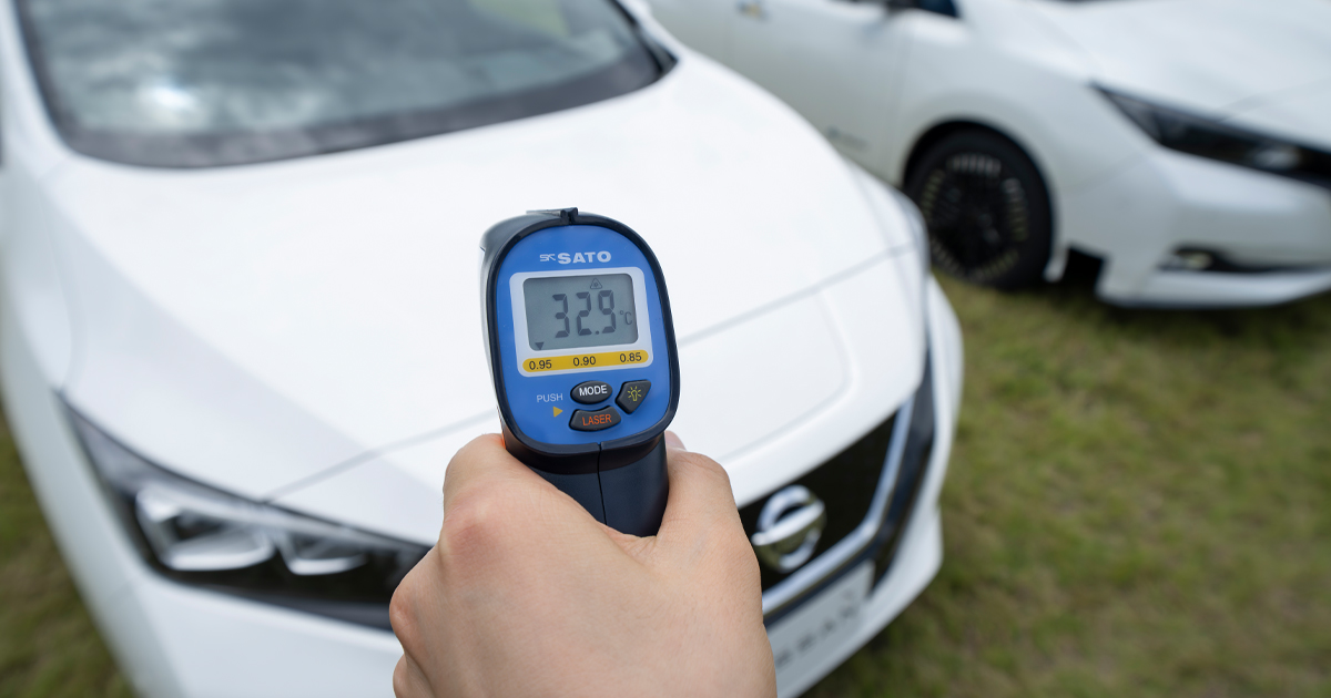 Taking a temperature reading of a white Nissan