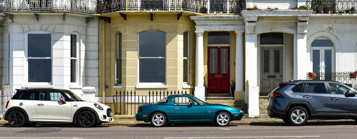 Cars parked outside a terraced house