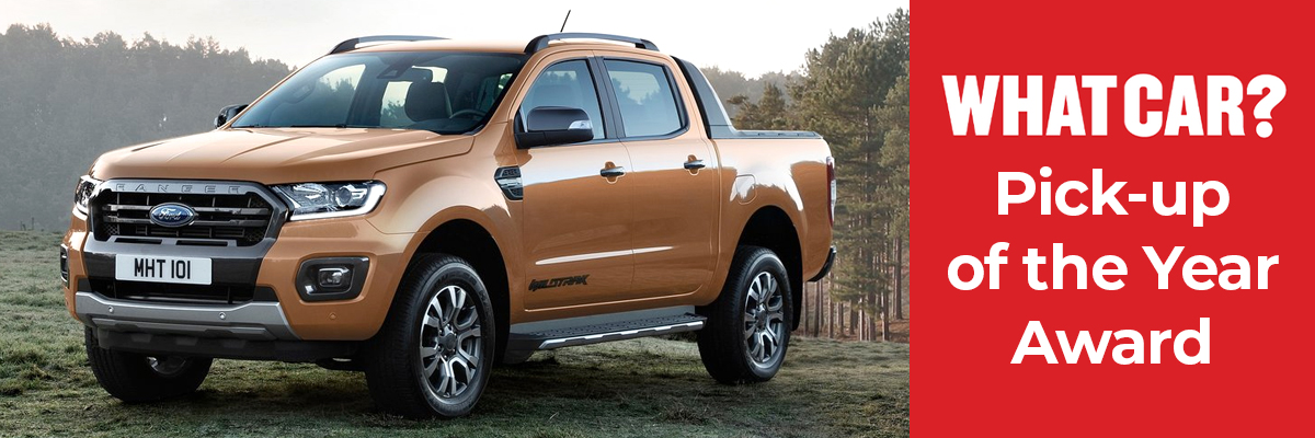 An orange Ford Ranger parked in a field