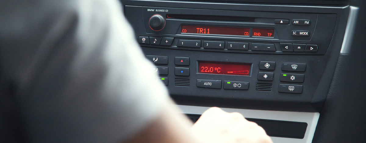 Person adjusting a 2000s style car radio