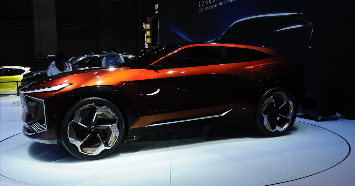 Side angle of a red Exeed at a motor show
