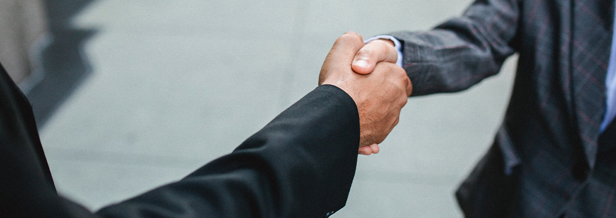 Two professional business people shake hands.