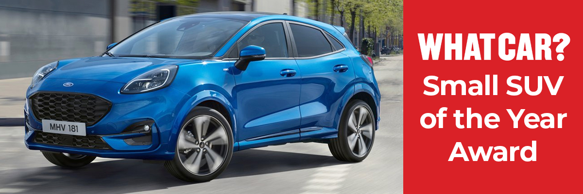 A blue Ford Puma driving down a road