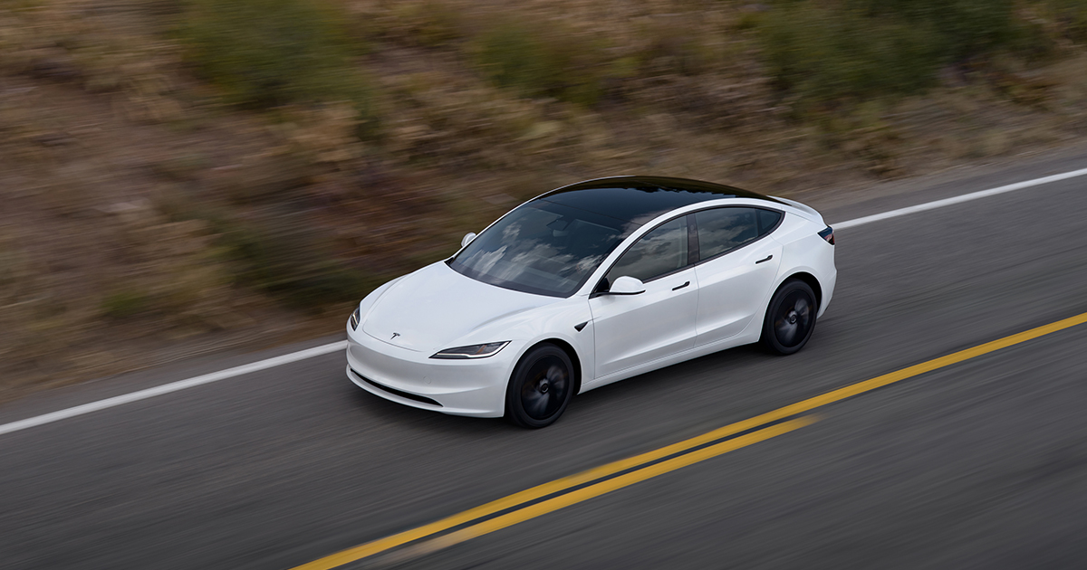 A white Tesla Model 3 Standard driving from above