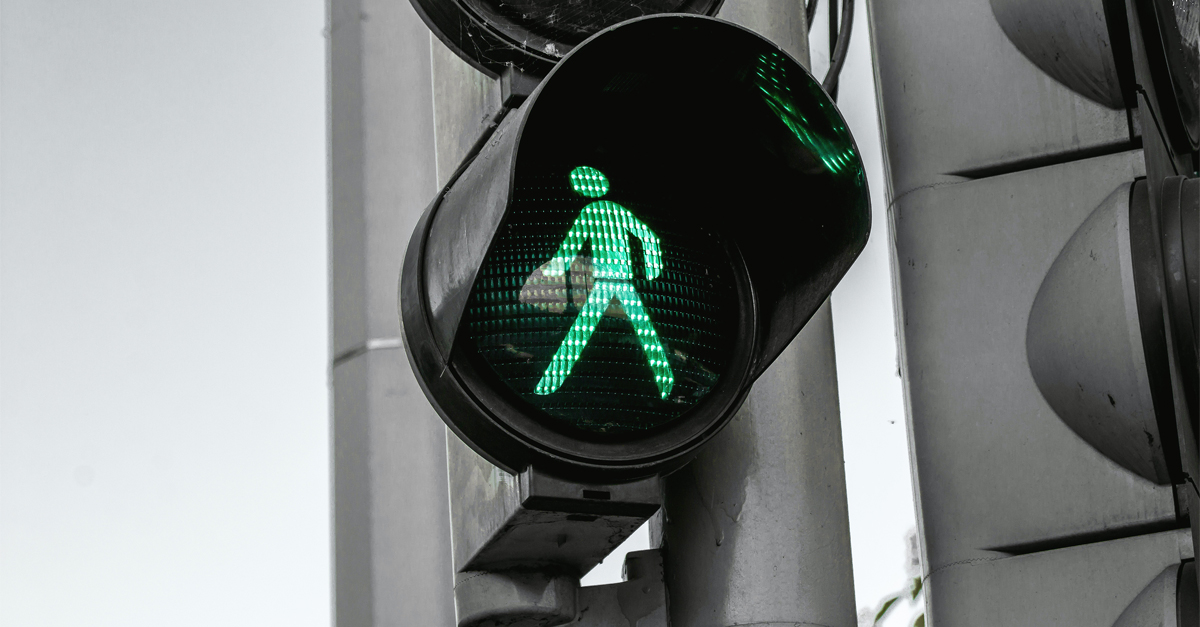 Close-up of a traffic light with a green person in it