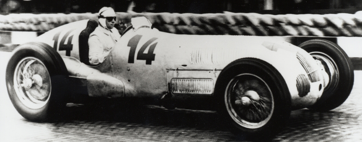 A classic race car vehicle with the driver sat inside