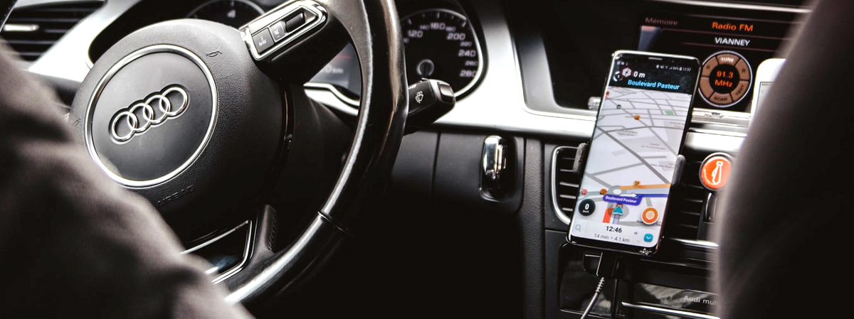 A car interior with a mobile phone showing a map