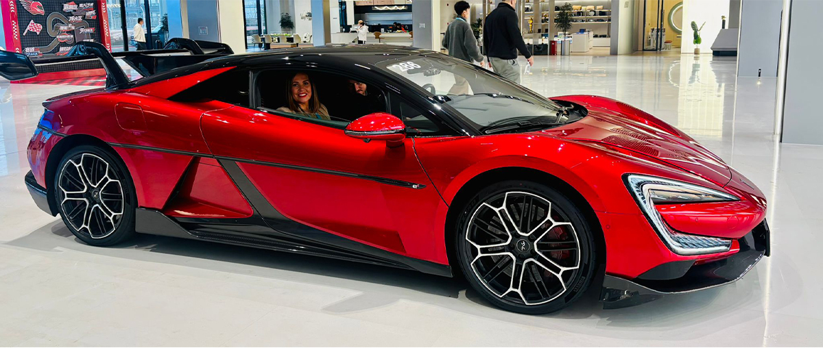 Vanessa sitting in a red Yangwan U9 - the world's fastest production car