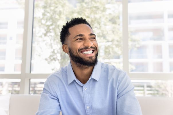A person smiling whilst leaning out of their salary sacrifice car.